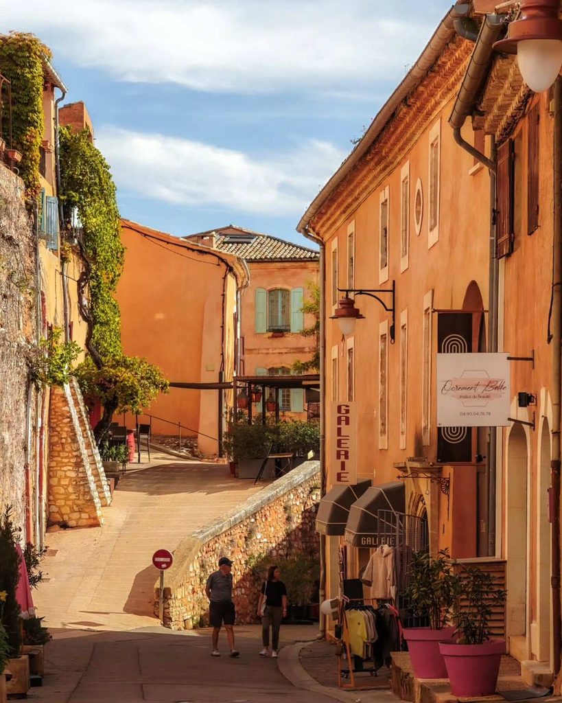 Place de la Mairie surrounded by ochre-coloured buildings in Roussillon