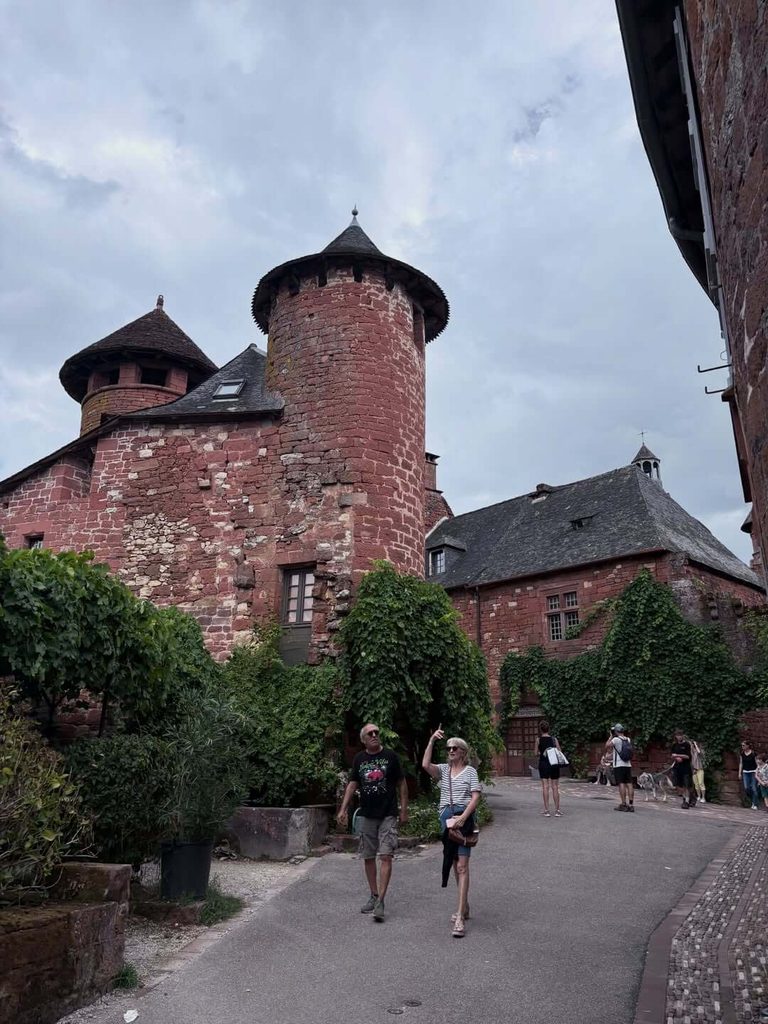 Visitor walking through the historic streets of Collonges-la-Rouge