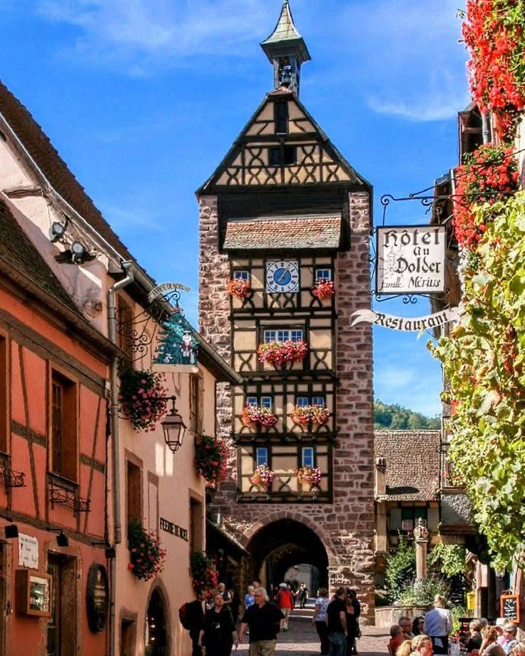 Visitors walking along Rue du Général de Gaulle in Riquewihr