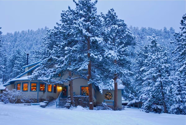 Charming view of Romantic RiverSong Inn in Estes Park, Colorado, featuring cozy cabin-style accommodations, lush riverside surroundings, and a peaceful mountain retreat atmosphere.