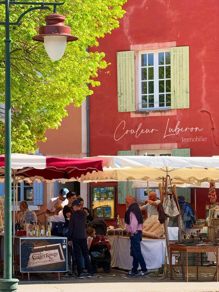 “Outdoor café table in Roussillon surrounded by ochre-coloured buildings”