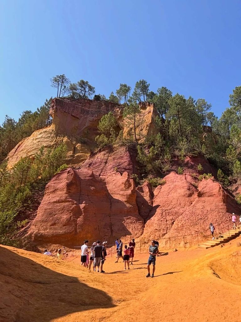 “Visitors walking the Sentier des Ocres in Roussillon during summer”