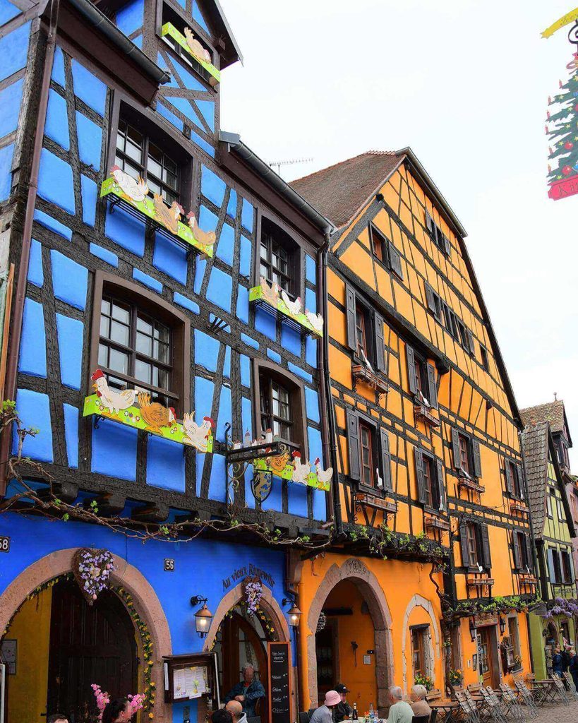 Rue du Général de Gaulle lined with historic half-timbered houses in Riquewihr