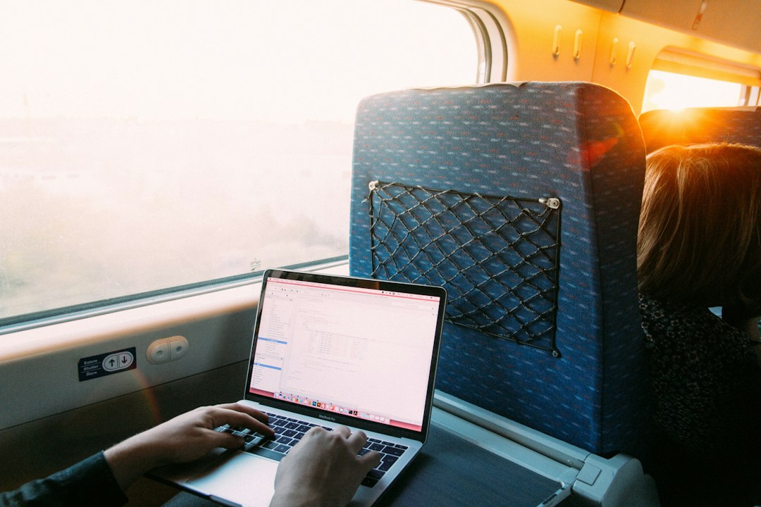 Traveler using a laptop beside a window at sunset
