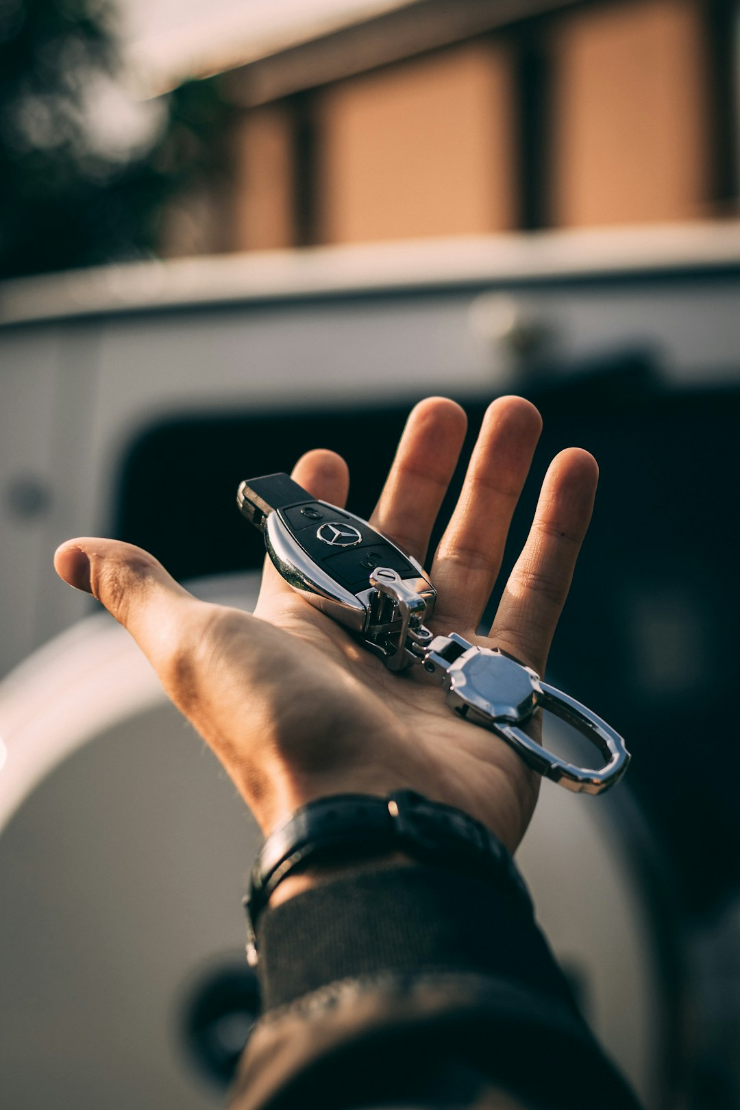 Person holding mercedes-benz fob