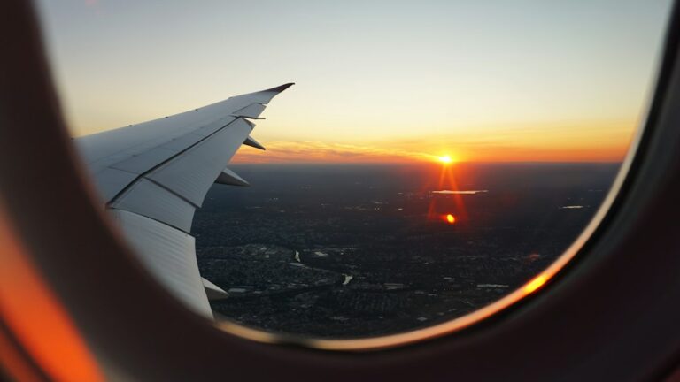 View of the sky and clouds through an airplane window during golden light