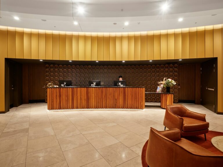 Modern hotel reception desk with wooden furniture and lobby seating