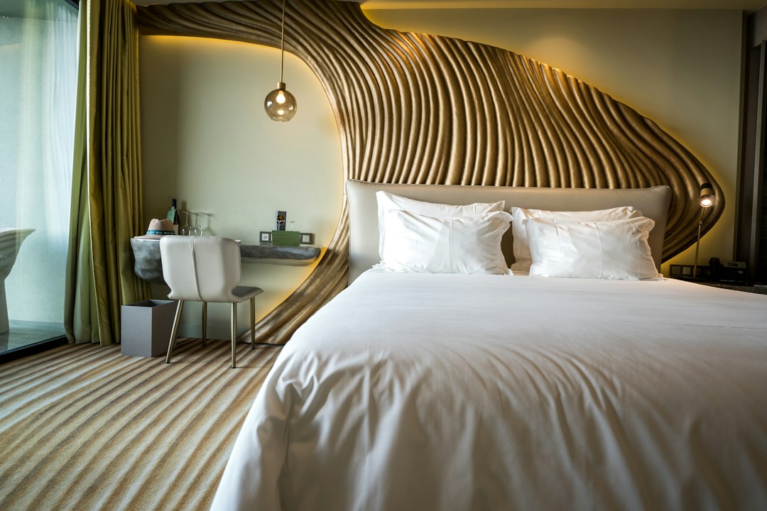 Hotel room with a neatly made white bed and a wooden headboard