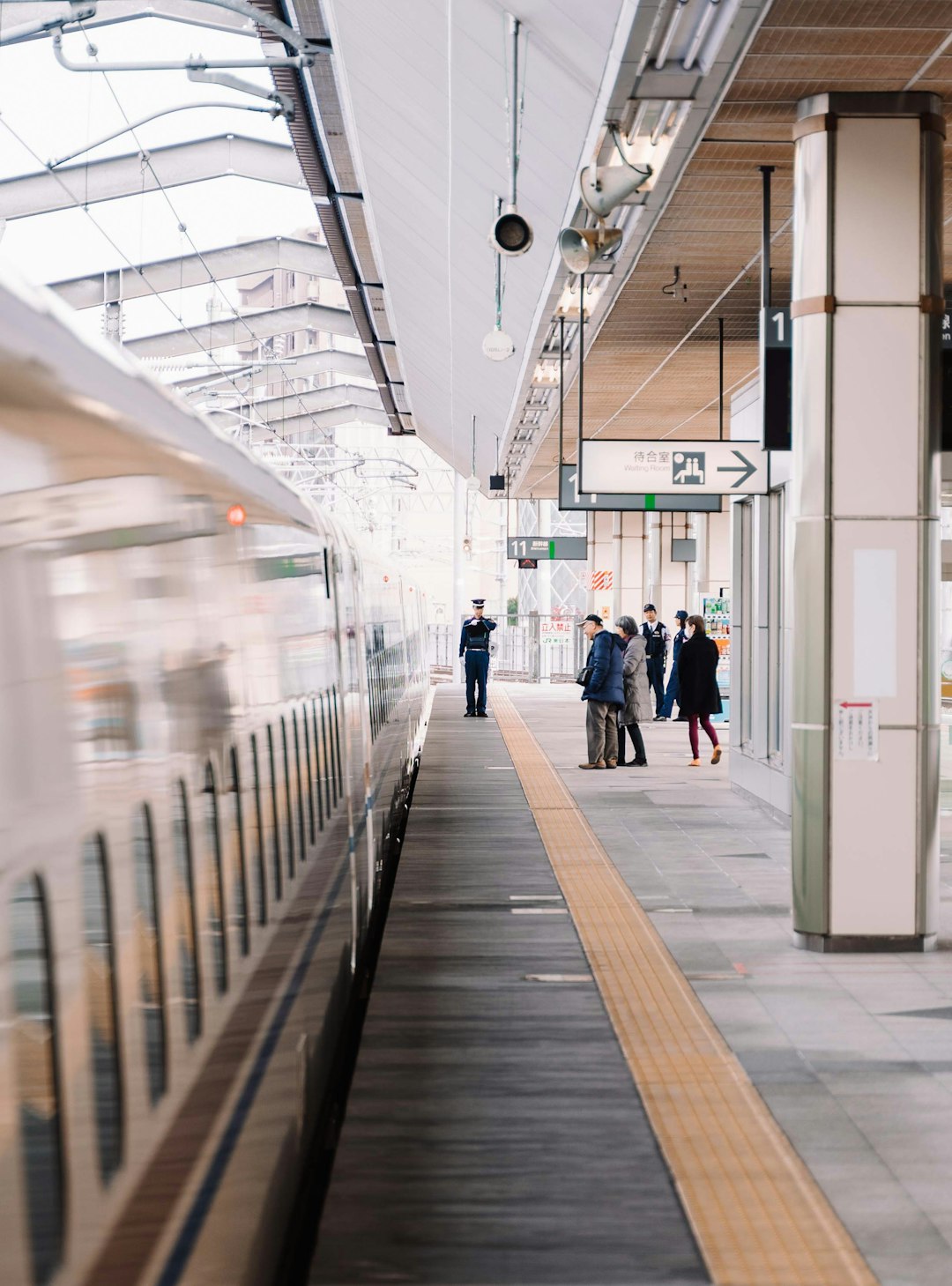 Shinkansen bullet train arriving at a Japanese station platform