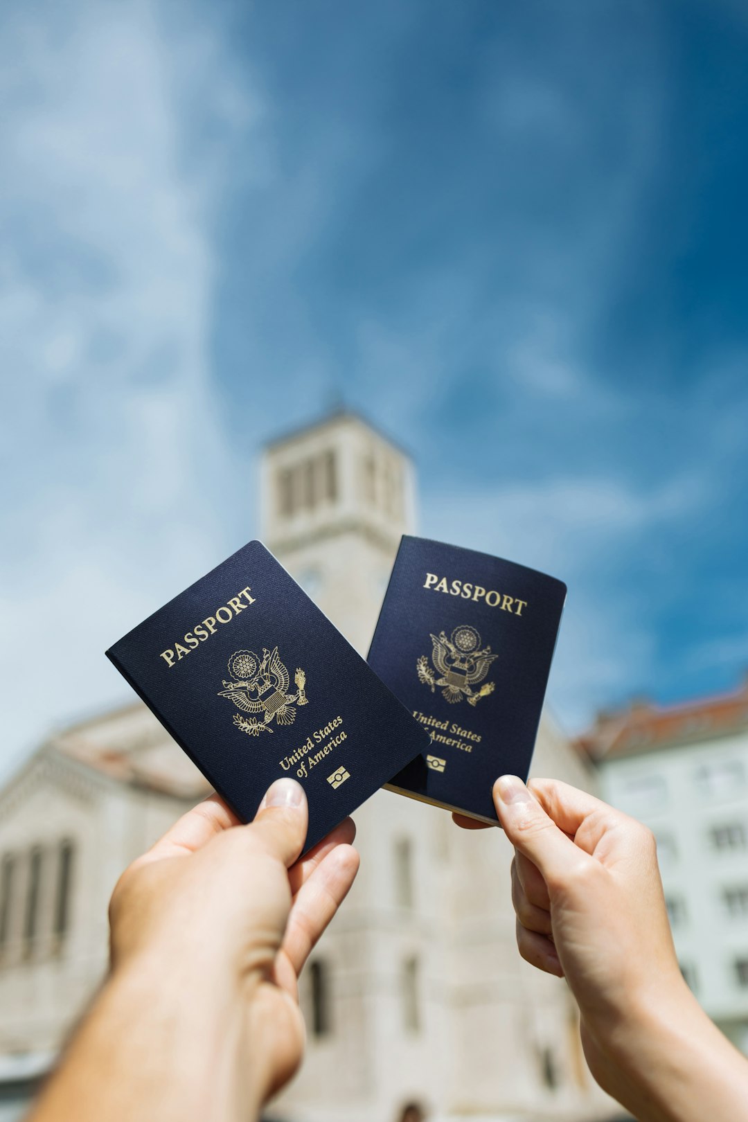 Travelers holding up their passports outside a building