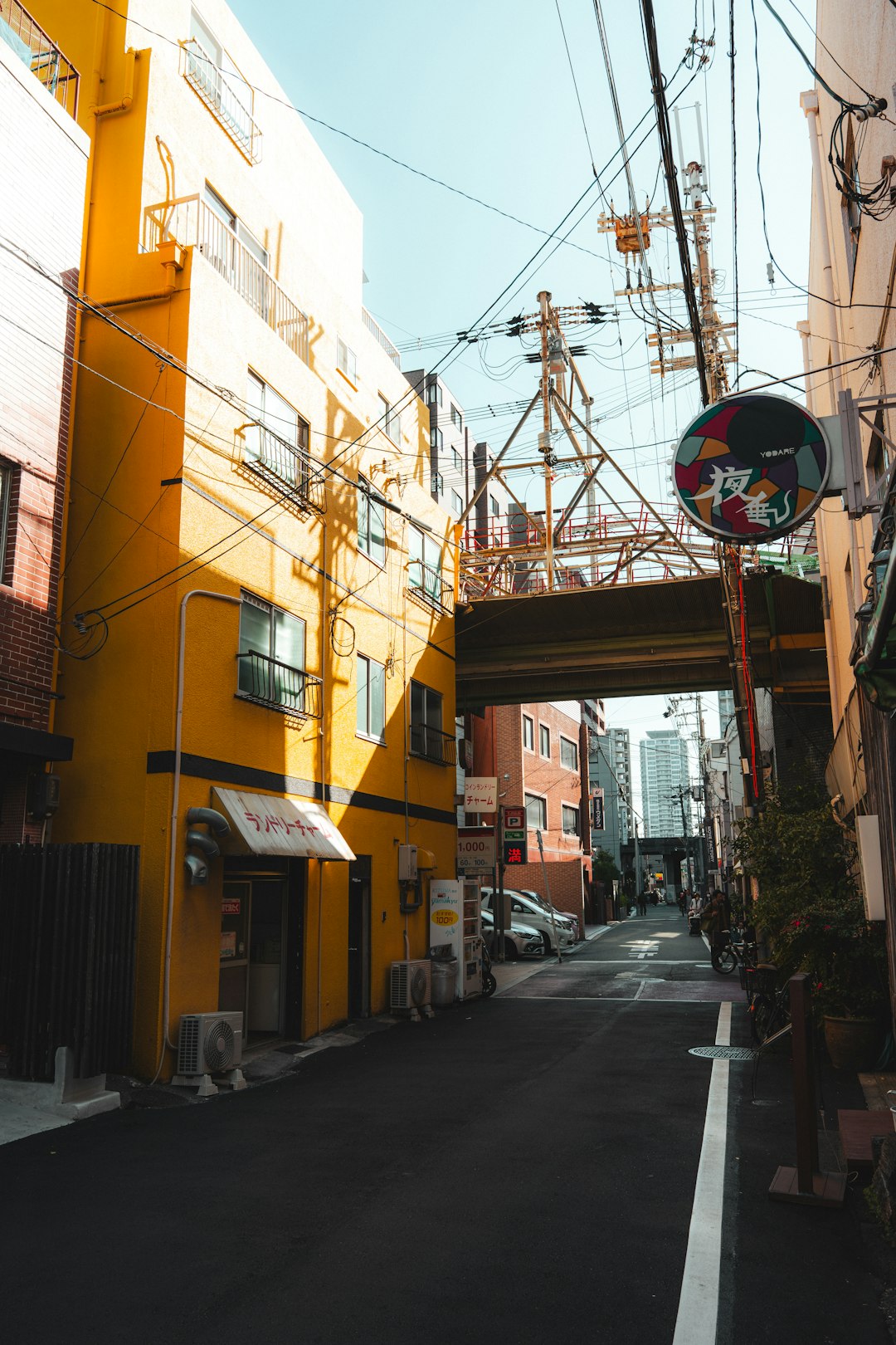 Narrow Japanese alleyway with a bright yellow building