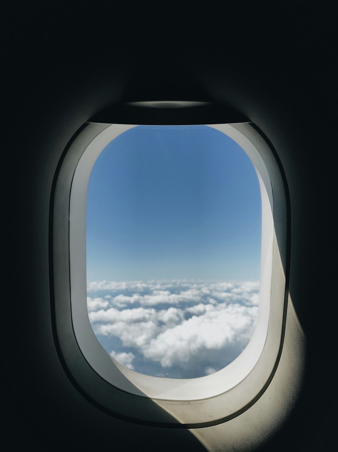 View of the wing and clouds from an airplane window seat