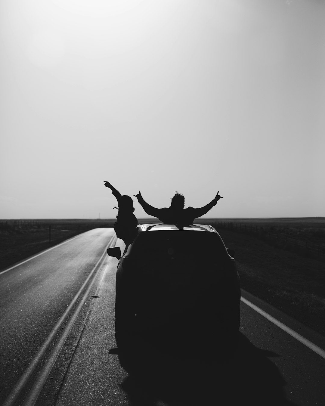 Grayscale photo of man riding on motorcycle on road