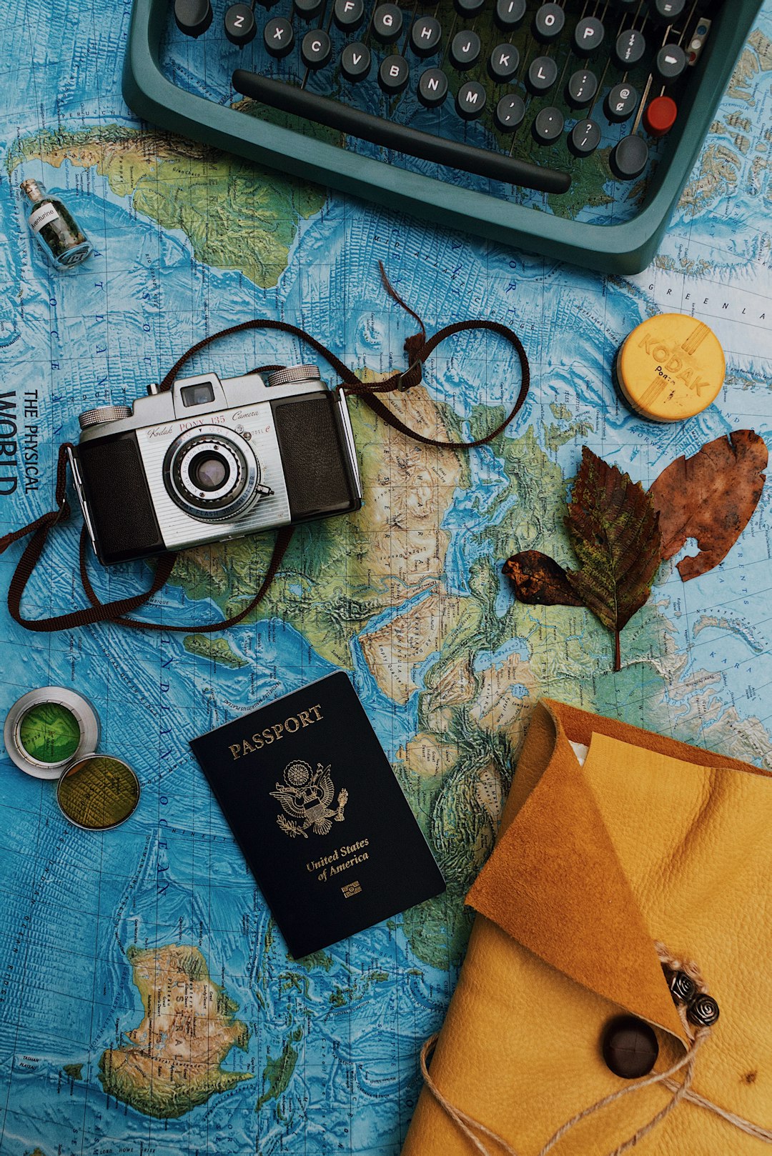 A passport laid out with a camera and travel gear before a trip