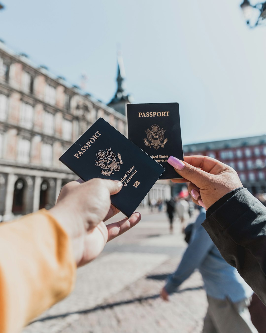 A person holding two passports in hand