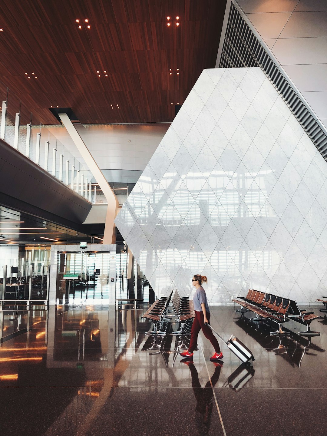 A person walking through an airport terminal with luggage
