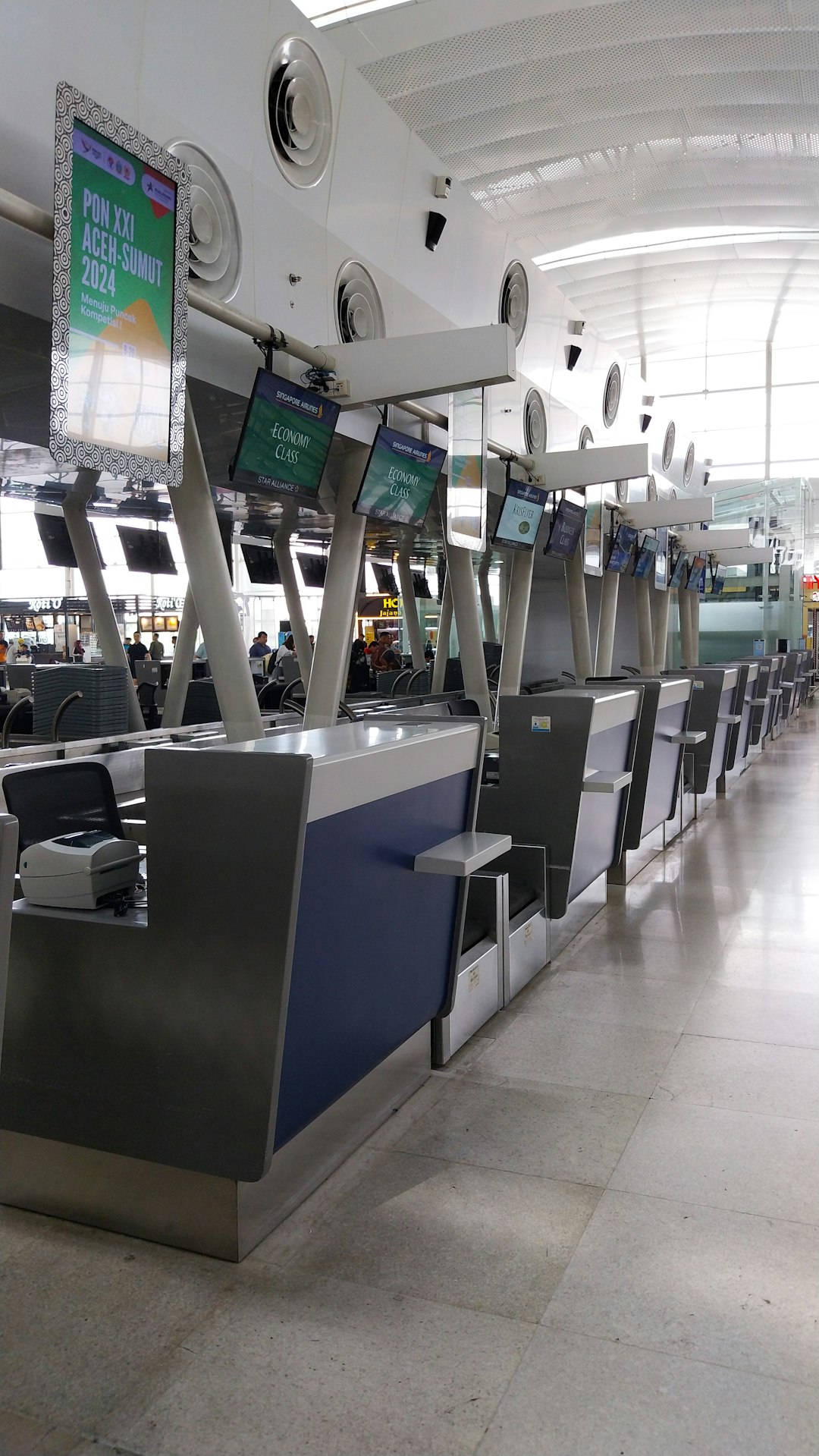 Baggage check-in counters inside a busy international airport hall