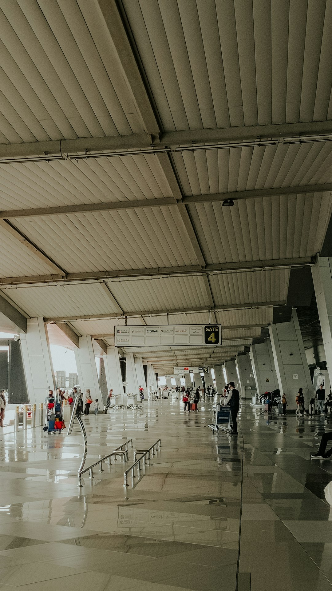 Crowds moving through a large, busy airport terminal