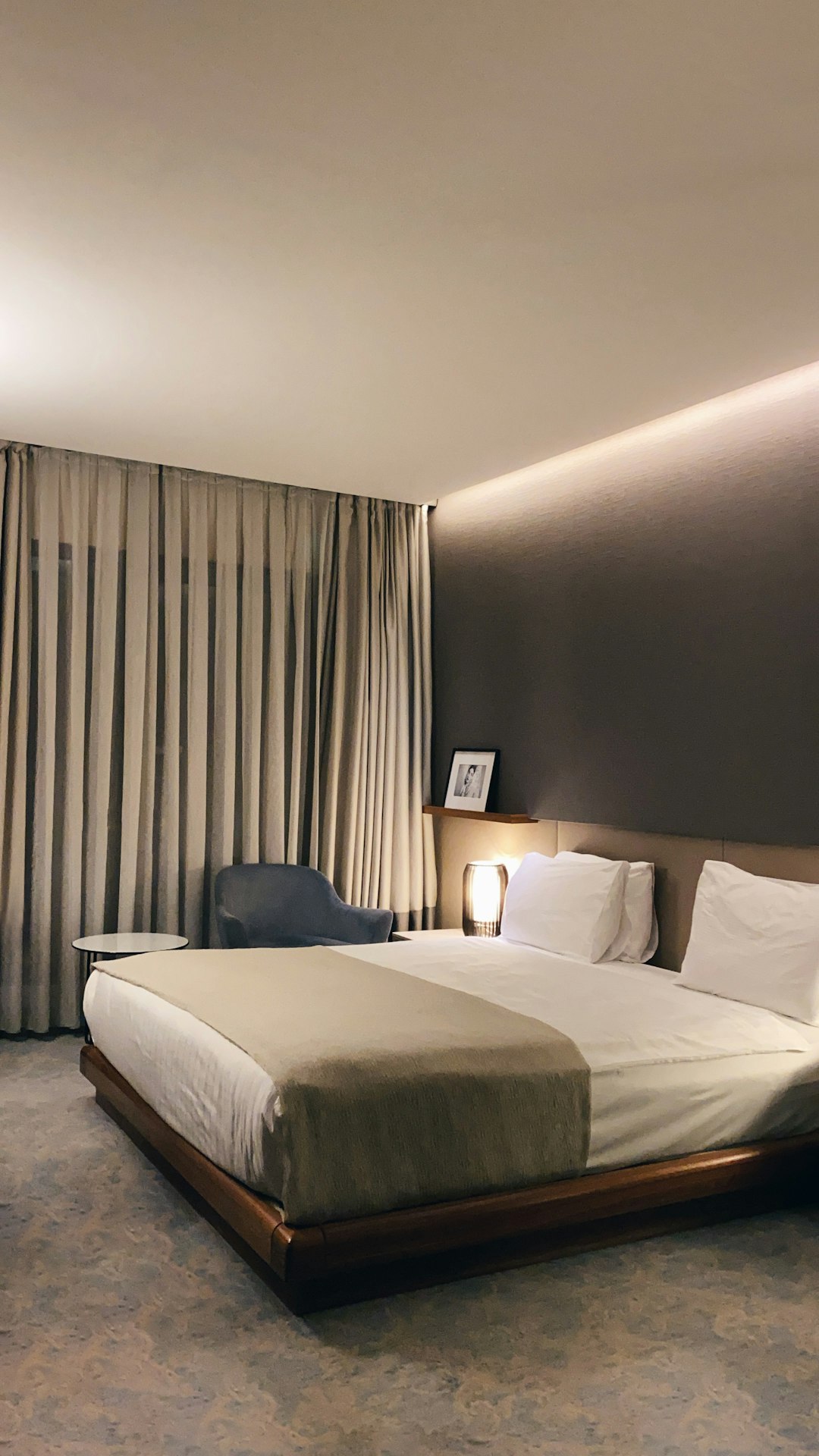 A neatly made bed in a tidy hotel room