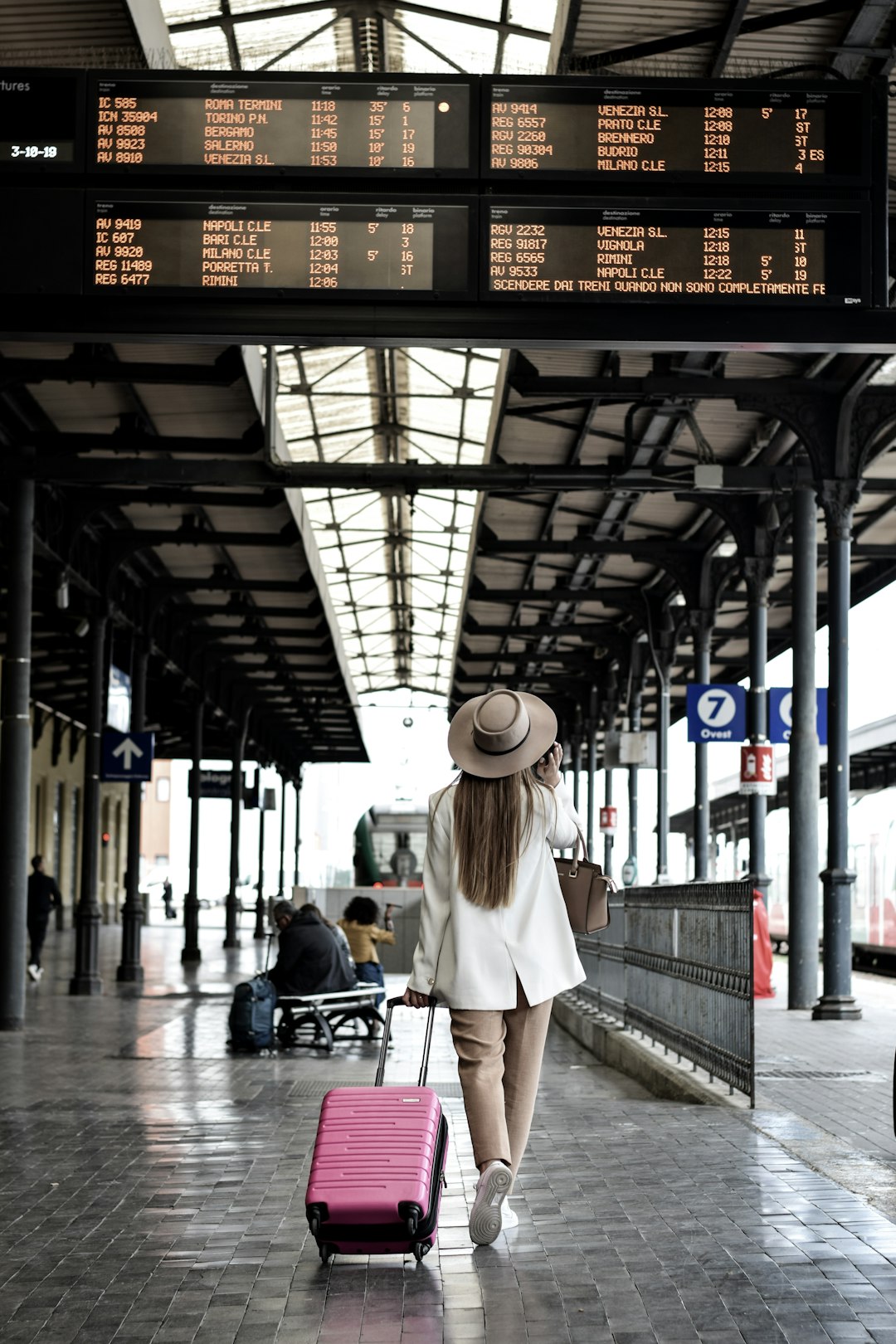 A traveler walking through an airport terminal with a rolling suitcase