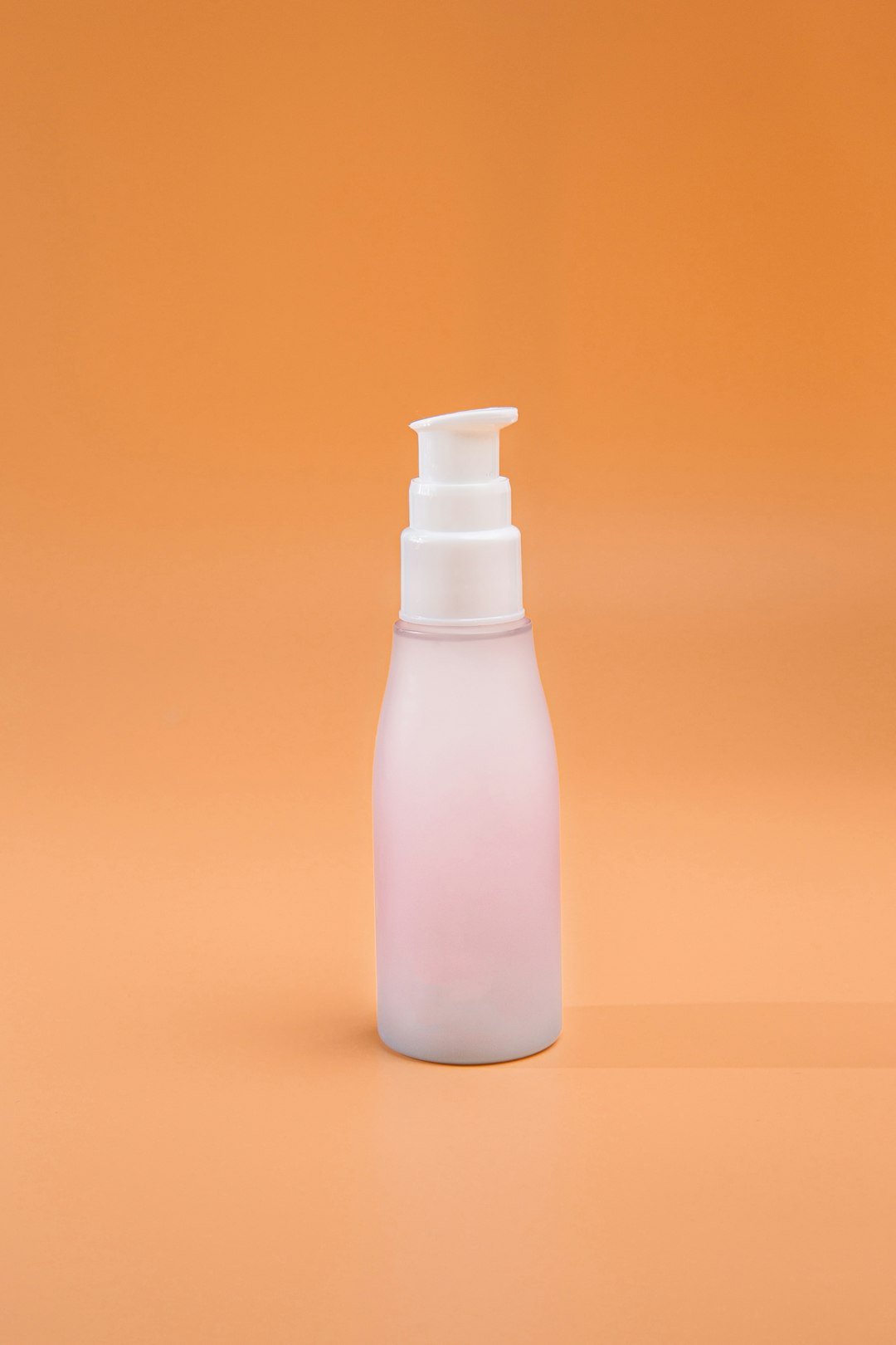 A travel-size toiletry bottle on a plain background